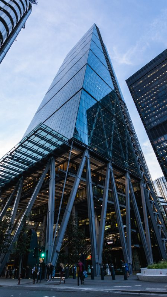 Modern corporate glass tower viewed from the plaza below
